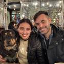 Two people with a dog indoors.